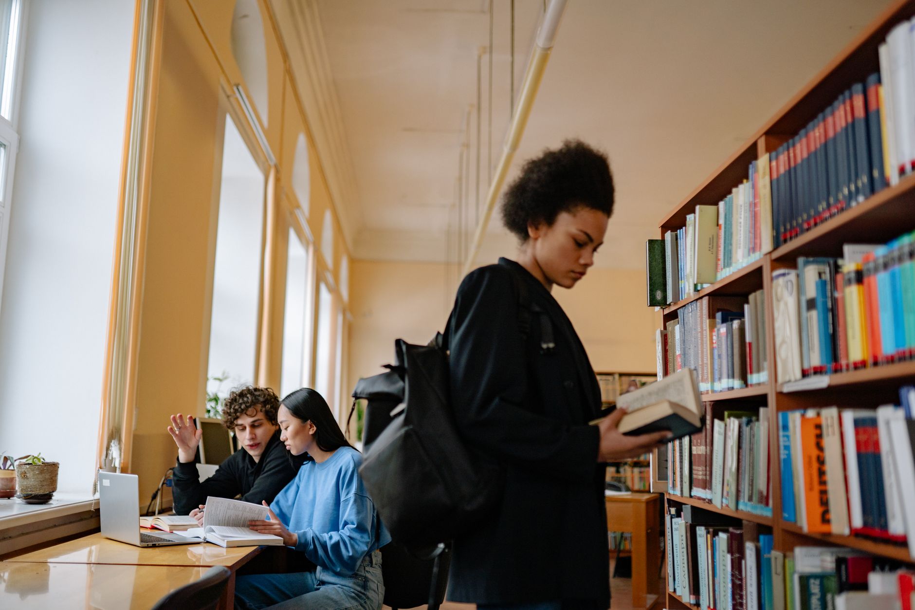 Adolescentes estudando em biblioteca, preparação para vestibular com apoio de chatbot