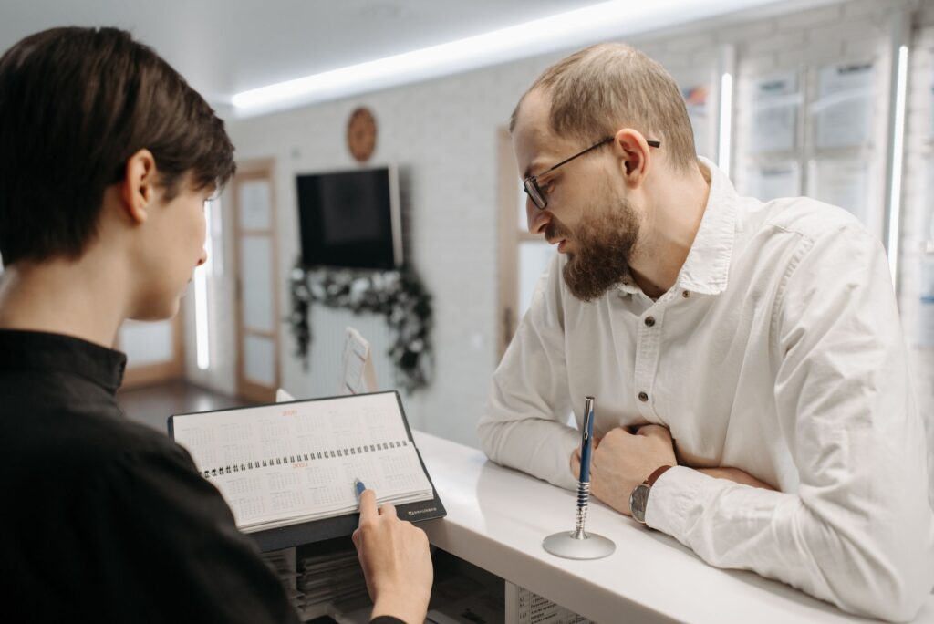 Recepcionista mostrando agendamento de consultas médicas whatsapp para paciente