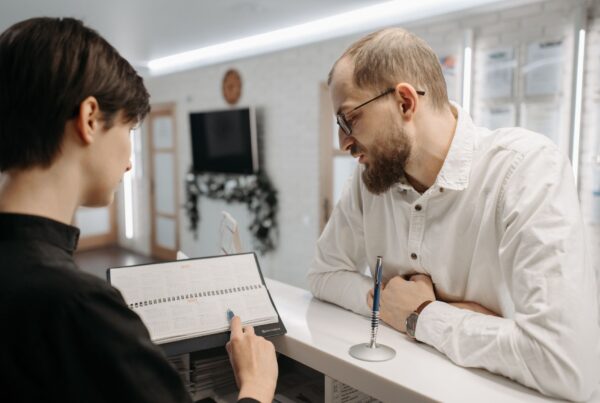 Recepcionista mostrando agendamento de consultas médicas whatsapp para paciente