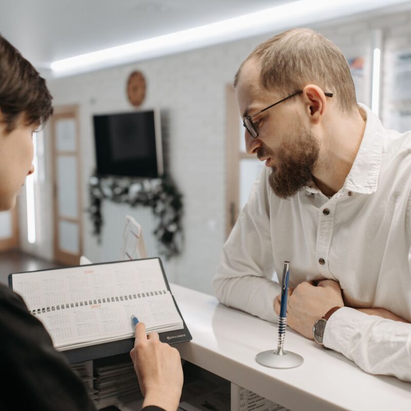 Recepcionista mostrando agendamento de consultas médicas whatsapp para paciente