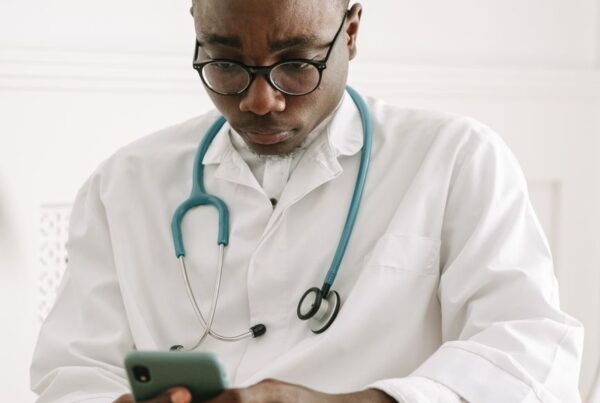 Médico usando o celular para atendimento automatizado para clínicas médicas via WhatsApp