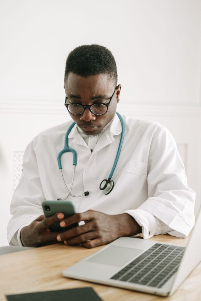 Médico usando o celular para atendimento automatizado para clínicas médicas via WhatsApp