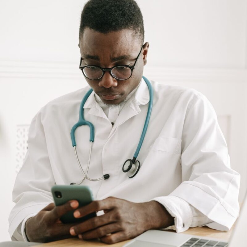 Médico usando o celular para atendimento automatizado para clínicas médicas via WhatsApp