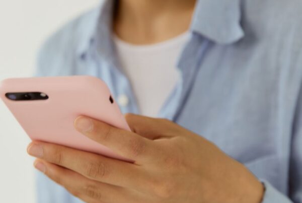 Tutora sorrindo ao conversar com chatbot para pet shop perguntas frequentes pelo celular