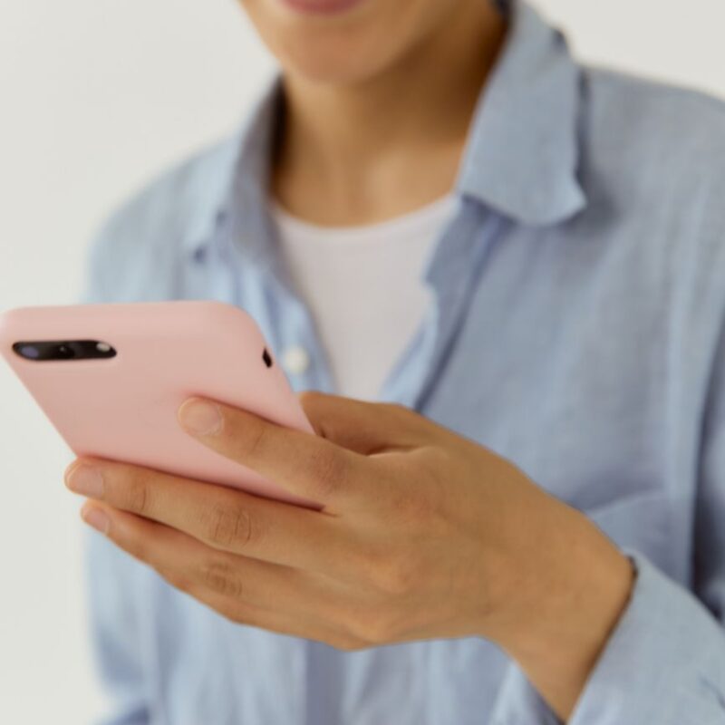 Tutora sorrindo ao conversar com chatbot para pet shop perguntas frequentes pelo celular