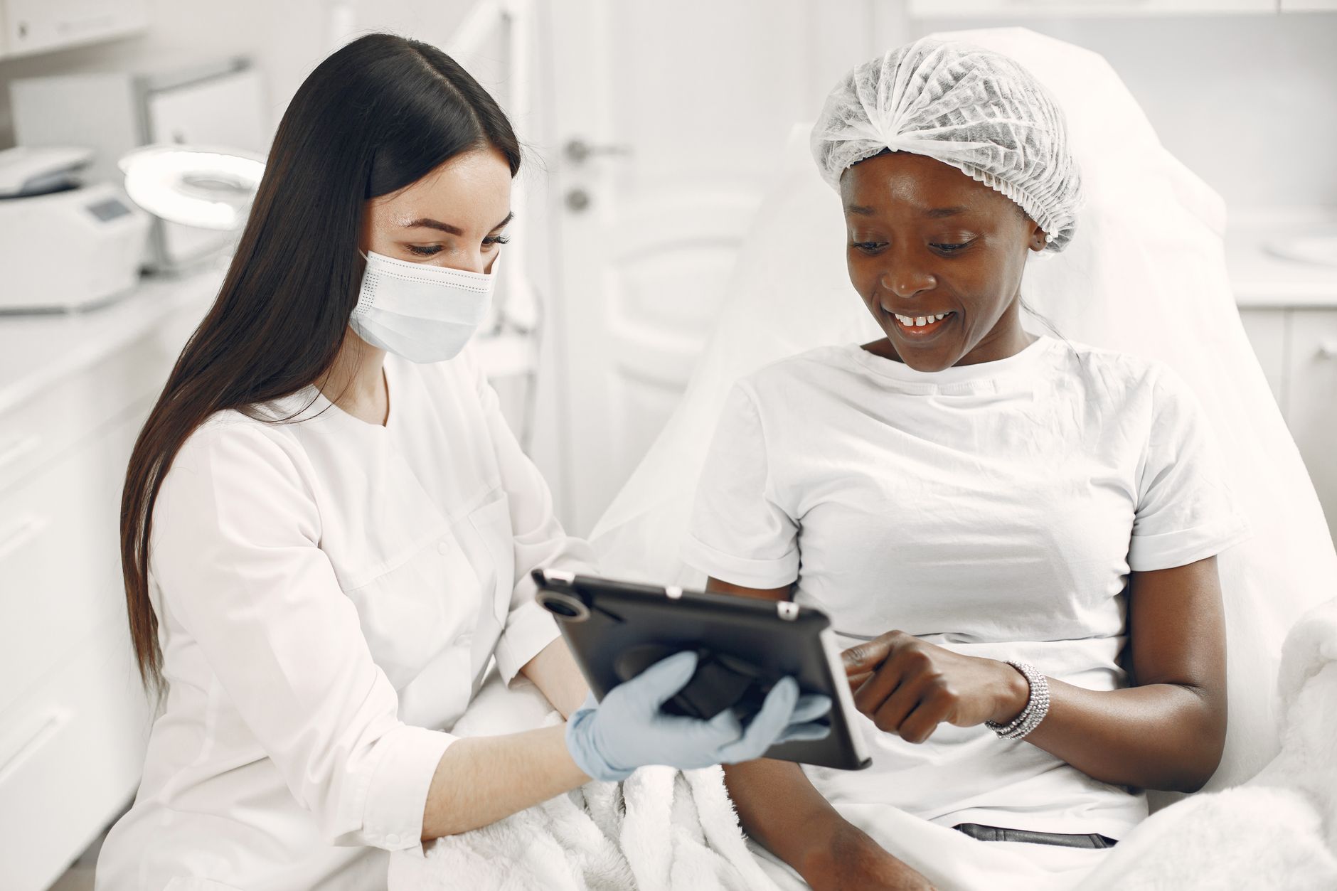 chatbot whatsapp clinica estetica consulta em Atendimento Automatizado para Clínicas de Estética: Guia Completo de IA no WhatsApp Profissional de clínica de estética consultando tablet com cliente durante atendimento