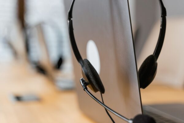Headset de atendimento sobre notebook, representando o suporte do WhatsApp
