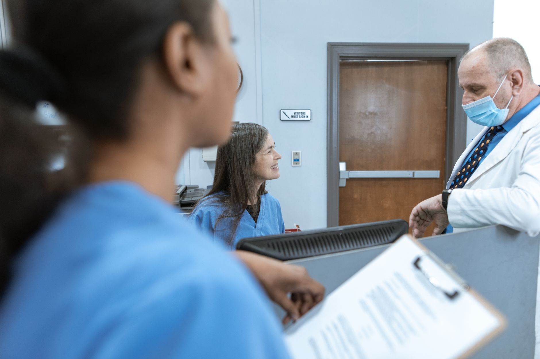equipe medica organizando jornada paciente em CRM para Clínicas Médicas: Como Organizar a Jornada do Paciente Equipe médica discutindo a jornada do paciente na recepção do hospital