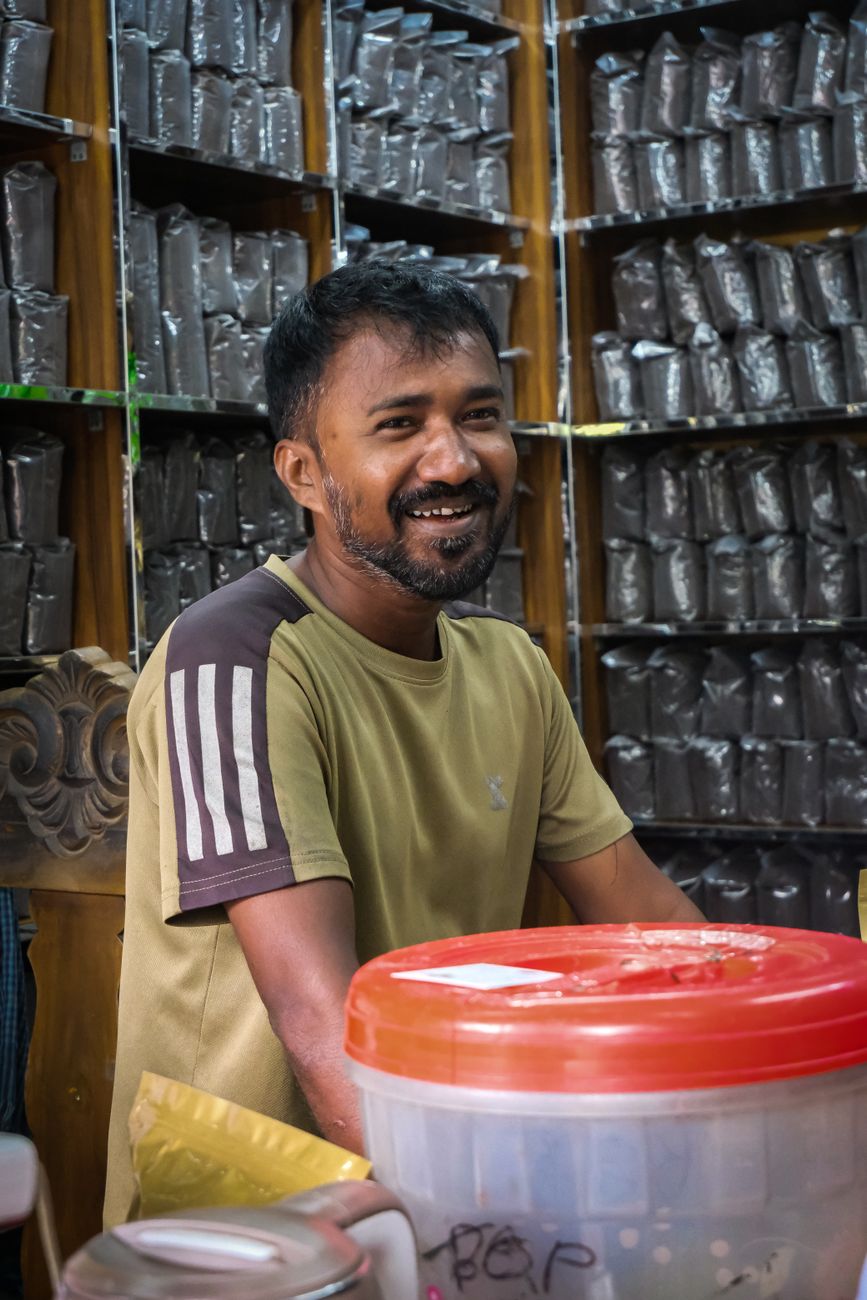 lojista sorrindo atendimento produtos em WhatsApp para Lojas de Varejo: Como Automatizar o Atendimento da Loja Física e Multicanal Lojista sorrindo em meio a produtos organizados na loja