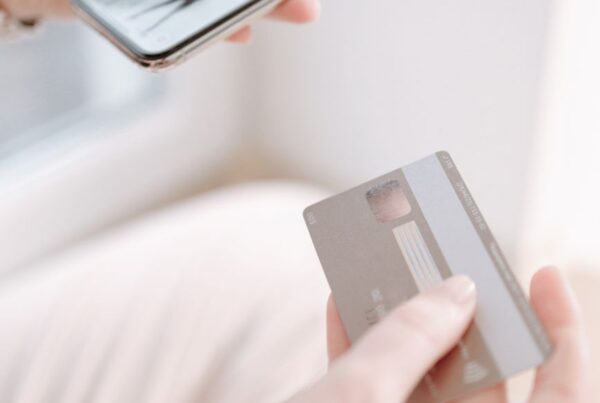 Pessoa segurando celular e cartão, ilustrando o mercado livre atendimento centralizado