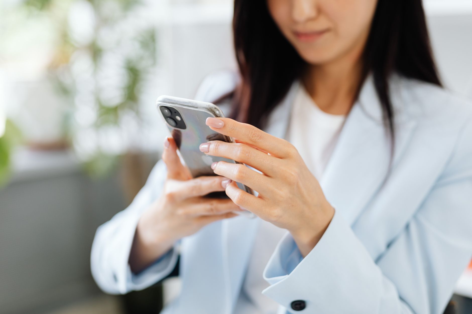 mulher consultando celular expediente escritorio em WhatsApp API Oficial Contabilidade: Por Que Migrar Agora Mulher consultando o celular durante expediente no escritório