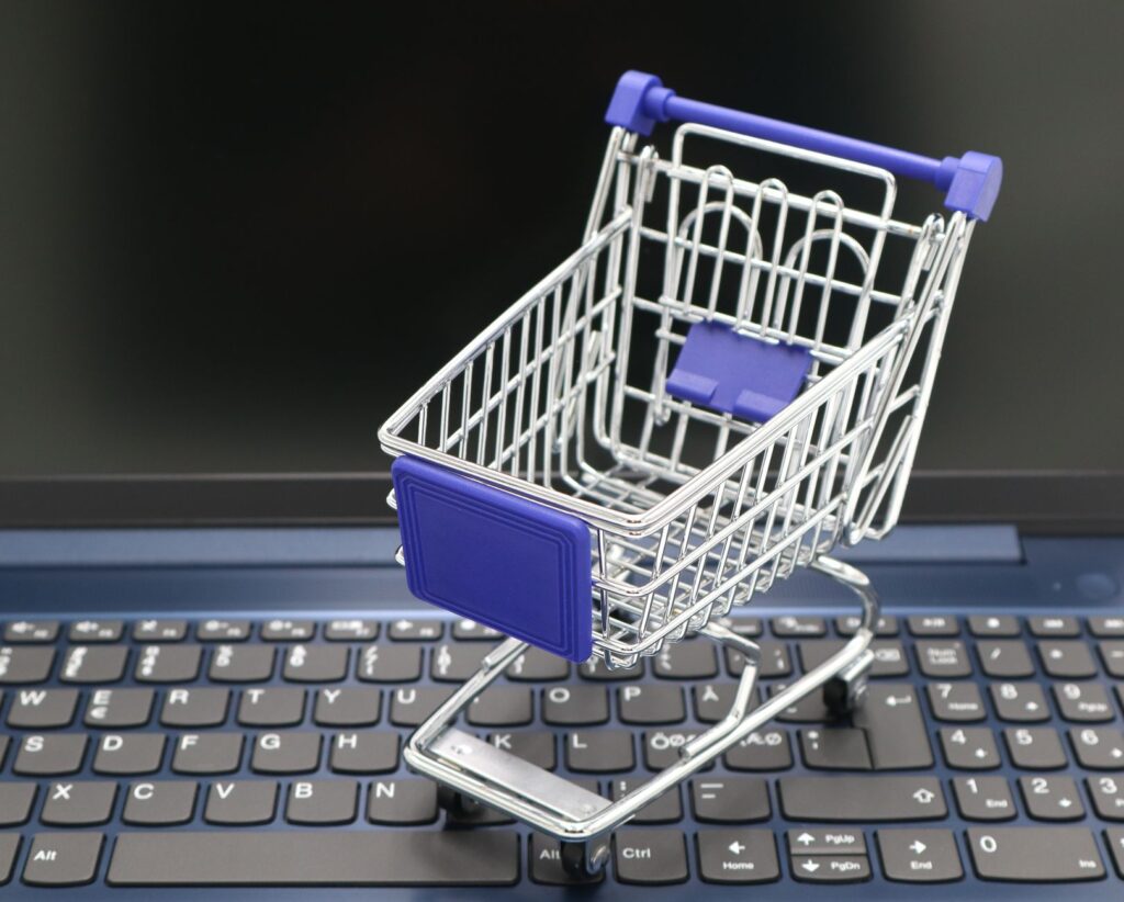 Carrinho de compras em miniatura sobre notebook, simbolizando a recuperação de carrinho whatsapp