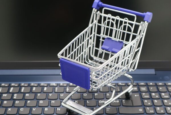 Carrinho de compras em miniatura sobre notebook, simbolizando a recuperação de carrinho whatsapp