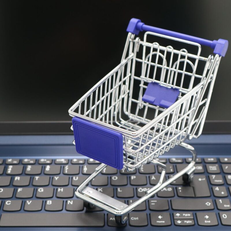 Carrinho de compras em miniatura sobre notebook, simbolizando a recuperação de carrinho whatsapp