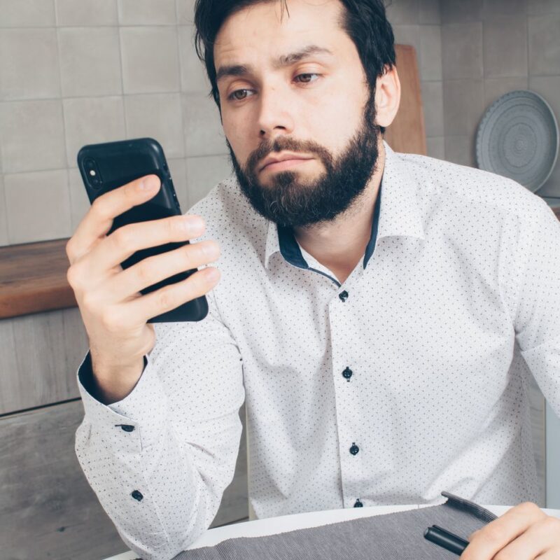 Pessoa frustrada olhando para o celular, ilustrando problema de WhatsApp que não abre