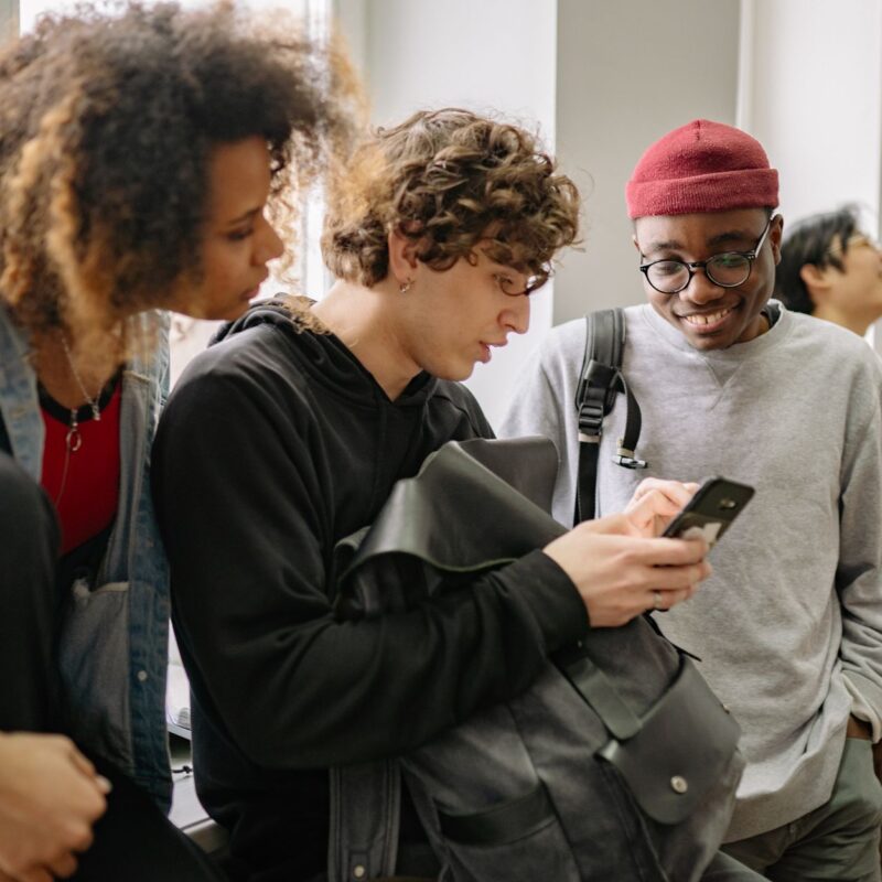 Grupo de estudantes usando celular representando whatsapp para educação