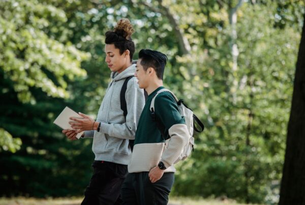 Estudantes universitários caminhando no campus, ilustrando o whatsapp para faculdades