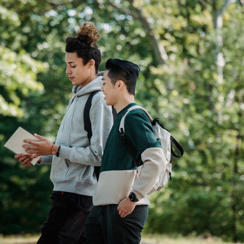 Estudantes universitários caminhando no campus, ilustrando o whatsapp para faculdades