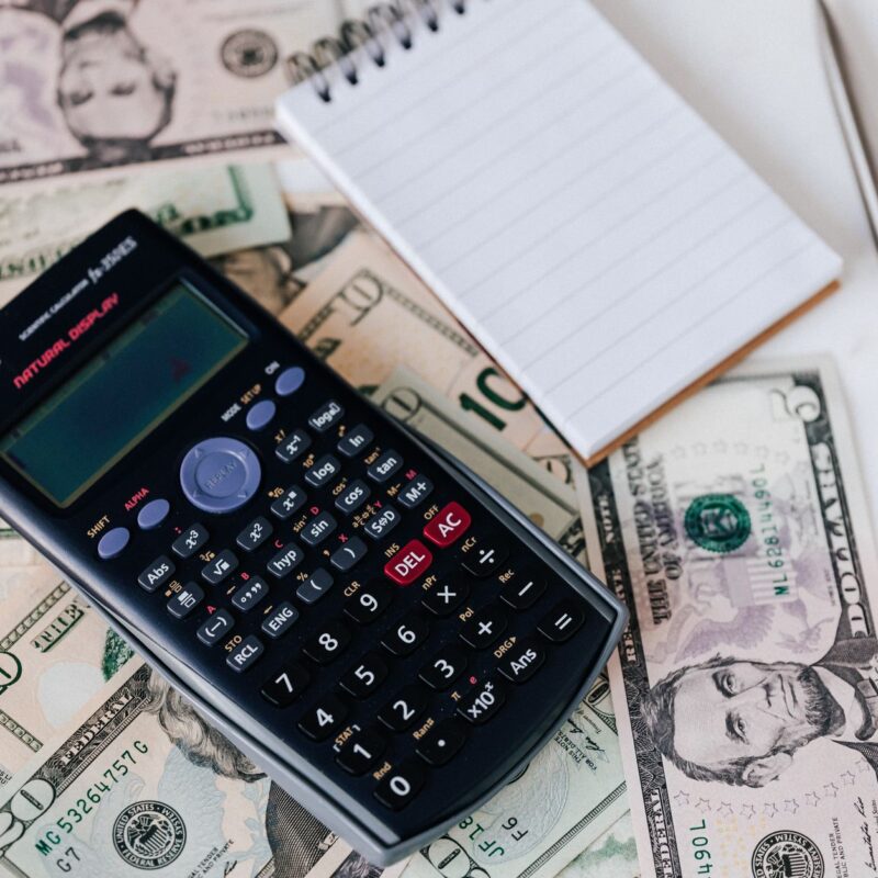 Calculadora e notas de dinheiro representando o custo do ChatGPT no atendimento