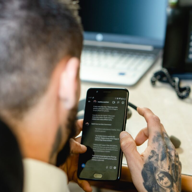 Profissional usando smartphone para enviar categorias de mensagens WhatsApp a clientes