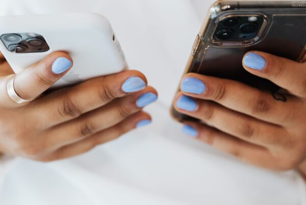 Mãos segurando dois celulares, representando a Conexão Híbrida WhatsApp entre API Oficial e conexão não oficial