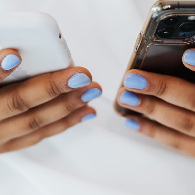 Mãos segurando dois celulares, representando a Conexão Híbrida WhatsApp entre API Oficial e conexão não oficial