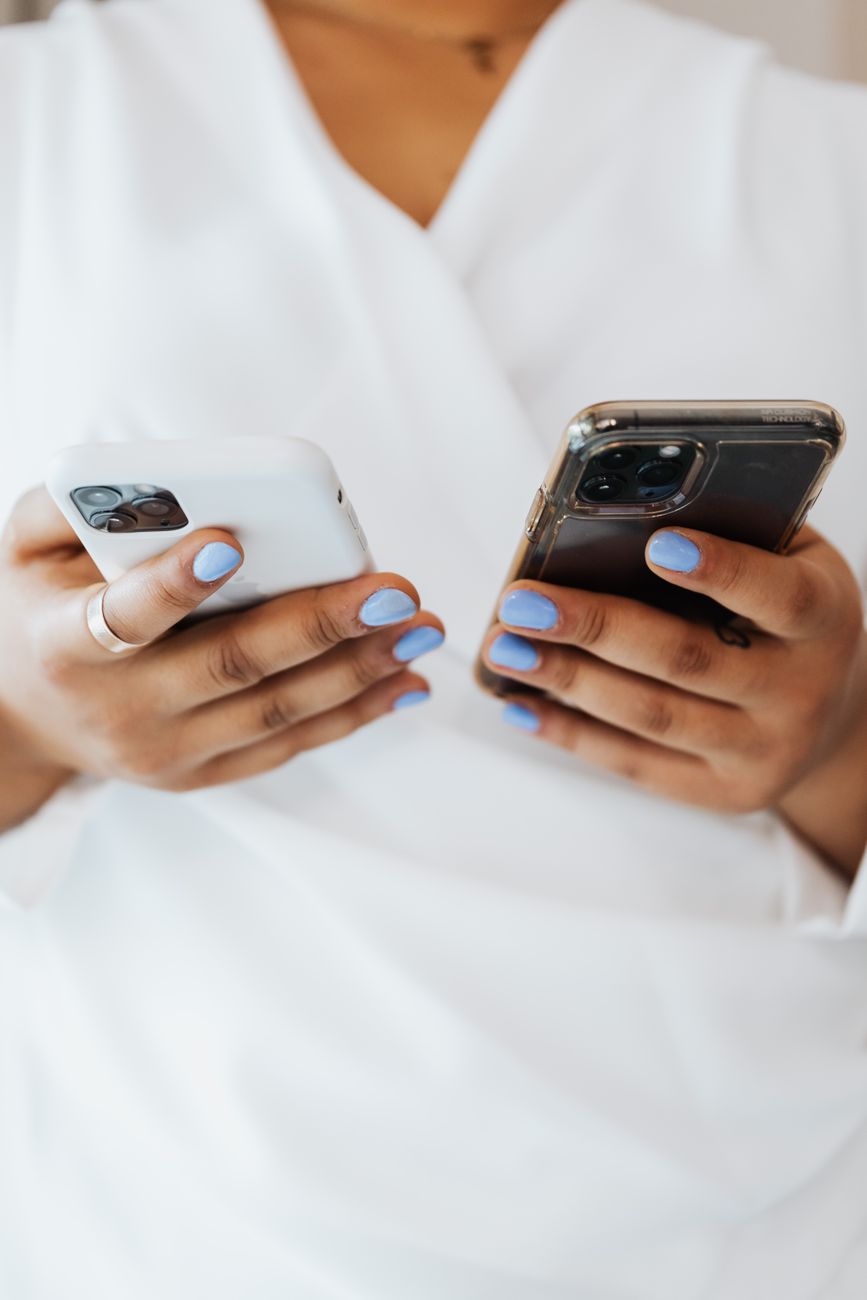 Mãos segurando dois celulares, representando a Conexão Híbrida WhatsApp entre API Oficial e conexão não oficial