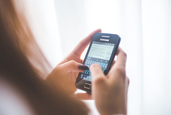 Mulher digitando no celular, representando o envio de templates WhatsApp Business aprovados